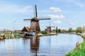 A row of water windmills on the river. Beautiful wind mills landscape. Windmill sails are moving by wind. Ecological energy