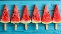 A row of watermelon slices on popsicle sticks against a blue background Royalty Free Stock Photo