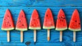 A row of watermelon slices on popsicle sticks against a blue background Royalty Free Stock Photo