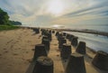 A row of weathered wave dissipating concrete blocks stand sentinel on a beach in the morning Royalty Free Stock Photo