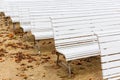 Row of white benches at an outdoor event Royalty Free Stock Photo