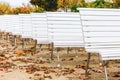 Row of white benches at an outdoor event Royalty Free Stock Photo