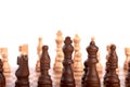 Row of white and black wooden chess pieces on a chessboard, isolated on white background Royalty Free Stock Photo