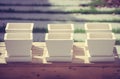 Row of white ceramic flowerpots on wooden box at outdoor garden in vintage style.