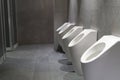 Row of white ceramic urinal chamber pot interior design with beautiful gret ceramic wall men public toilet or restroom with copy Royalty Free Stock Photo