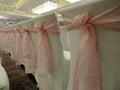 Row of white chairs decorated with pink bows Royalty Free Stock Photo