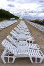 Row of white chairs for sunbathing on the sandy beach Royalty Free Stock Photo