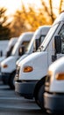 Row of White Delivery Trucks Parked in Daylight Close-Up View Royalty Free Stock Photo