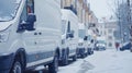 Row of white delivery vans on snowy day, transport service concept with copy space Royalty Free Stock Photo