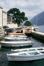 Row of white fishing boats stands on the pier of Perast. Montenegro