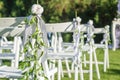 Row of white folding chairs before a wedding ceremony. Seats for guests Royalty Free Stock Photo