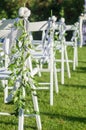 Row of white folding chairs before a wedding ceremony. Vertical orientation Royalty Free Stock Photo