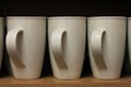 A Row White Mugs sat on a shelf Royalty Free Stock Photo