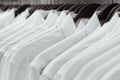 Row of white shirts hang on black hangers on a rack in a shop Royalty Free Stock Photo