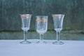 A row of white three glass crystal goblets on a gray table Royalty Free Stock Photo