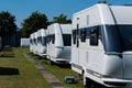 A row of white touring caravans on standing on a sunny day in summer