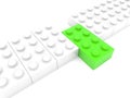 A row of white toy bricks with a green brick in the middle