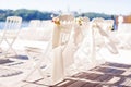 Row of white wedding chairs decorated with flowers Royalty Free Stock Photo