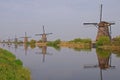 A row of windmill from front to back in kinderdijk with beautiful river water reflection Royalty Free Stock Photo