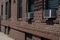 Row of Window Air Conditioners Outside an Old Brick Apartment Building in Astoria Queens New York Royalty Free Stock Photo
