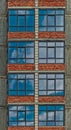 Row of the windowa of apartment building in development state with reflections of blue sky in window glass Royalty Free Stock Photo
