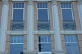 A row of windows on a brown wall with gray columns Royalty Free Stock Photo