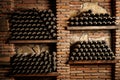 A row of wine bottles are displayed on shelves made of wood and bricks Royalty Free Stock Photo