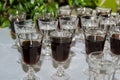 A row of wine glasses drinkware, filled with red alcoholic beverage, displayed on a table. Party preparation