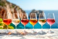 Row of wine glasses with varying shades of rose and white wine on marble bar with seascape background Royalty Free Stock Photo