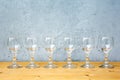 Row of wine glasses on wooden table with grey background Royalty Free Stock Photo