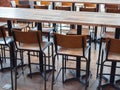 Row of wooden bar stools and wooden table Royalty Free Stock Photo