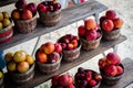 Row of wooden baskets full of fresh picked plums and peaches on shelves display at roadside market stand in Santa Rosa, Destin, Royalty Free Stock Photo