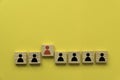 A row of wooden cube with people icon with one red people standing out from other Royalty Free Stock Photo