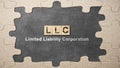 A row of wooden cubes with LLC text, the acronym of Limited Liability Company