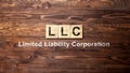 A row of wooden cubes with LLC text, the acronym of Limited Liability Company