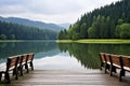 a row of wooden seats overlooking a tranquil lake Royalty Free Stock Photo