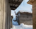 Row of wooden sheds covered with snow. Icicles hanging from the