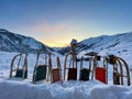 Row of wooden sledges standing in snow, Swiss Alps in the background. Partnun, Graubuenden, Switzerland. Royalty Free Stock Photo