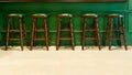 Row of wooden stools in front of green counter bar interior at the and pub, restuarant for drinking refresh relaxation in day life Royalty Free Stock Photo