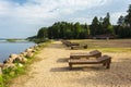 A row of wooden sun beds on the beach. Sunlight, water and sand. The beach on the lake of the tourist base