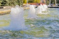 Row of working jet fountains in the city Park. Shallow depth of field. Bright sunny day in summer. Royalty Free Stock Photo