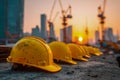Row of worn yellow construction helmets lined up on a rough concrete surface at a building site during a vibrant sunset with Royalty Free Stock Photo