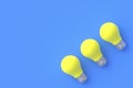 Row of yellow light bulbs on blue background Royalty Free Stock Photo