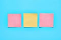 Row of yellow and red square blank paper stickers on blue background. Copy space Royalty Free Stock Photo