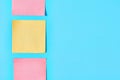 Row of yellow and red square blank paper stickers on blue background. Copy space Royalty Free Stock Photo