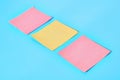 Row of yellow and red square blank paper stickers on blue Royalty Free Stock Photo