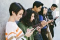 Row of Young Millennials Text on their Smart Phones - Men - Women - Screen Time - Modern Gathering Royalty Free Stock Photo