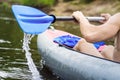 A rower in a boat with an oar. A man rafts on a kayak on the river. Rafting in a canoe with an oar. Active rest on the river