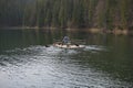 Rower on a raft in the middle of Lake Synevir. Carpathian mountains. Ukraine.