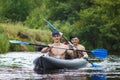 Rowers are rafted along river in a kayak. Two friends are swimming in boat on river and rowing oars on the water Royalty Free Stock Photo